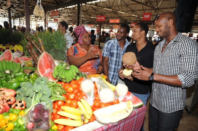 Photo By Lowrie-Chin Nesta Carter, Michael Frater and Asafa Powell show Gold Medal support for the Eat Jamaican Campaign as they commend Coronation Market vendor Angela Jarrett.